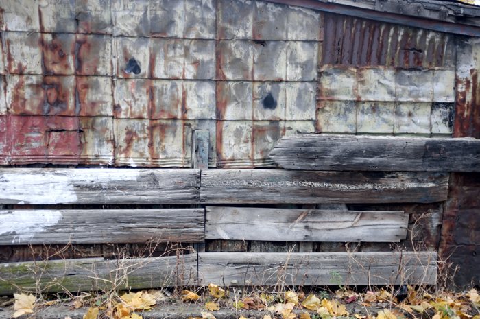 Rusty wall with patches of wood