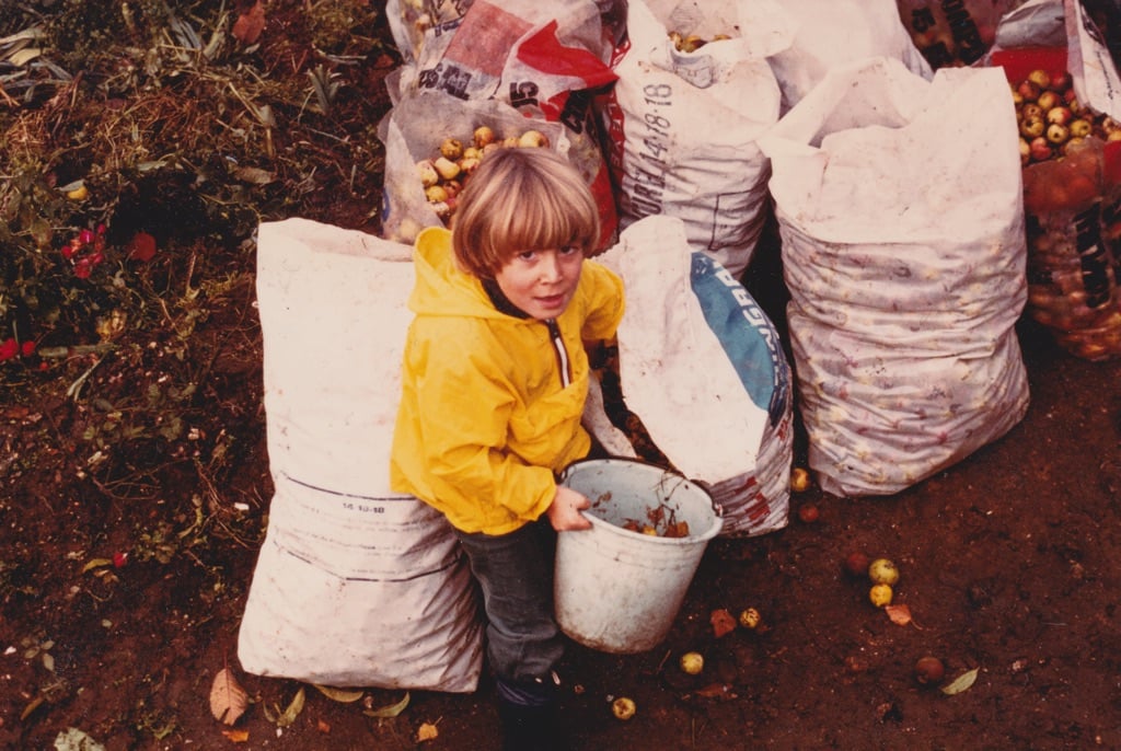 child filling bags with apples.